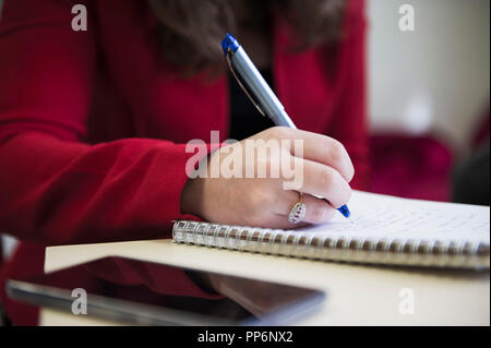 Note-taking on a notebook with a pen during a business meeting Stock Photo