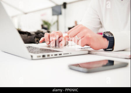 Note-taking on a computer during a business meeting: someone’s hands typing on a keyboard Stock Photo