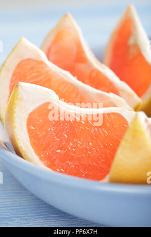 Slices of pink grapefruit in the blue bowl Stock Photo