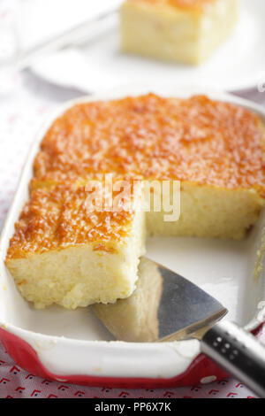 An English cake in a baking dish on a wooden board and a white wooden  table. Selective focus Stock Photo - Alamy