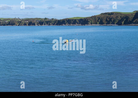 Castlehaven, West Cork, Ireland 24th September, 2018. A glorious Indian Summers day down in West Cork, a sole shrimp fisherman tends his pots on a flat calm blue sea on a warm Indian Summers day. The temperatures up to 15 Deg C and light breeze with the same expected tomorrow. Credit: aphperspective/Alamy Live News Stock Photo