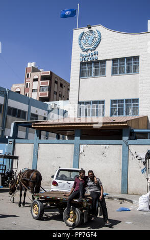 Gaza City, The Gaza Strip, Palestine. 24th Sep, 2018. Palestinian seen front of the closed gates of the United Nations Relief and Works Agency (UNRWA) headquarter during a general strike against the recent decisions taken by the Agency's administration towards employees in Gaza City. Credit: Mahmoud Issa/SOPA Images/ZUMA Wire/Alamy Live News Stock Photo