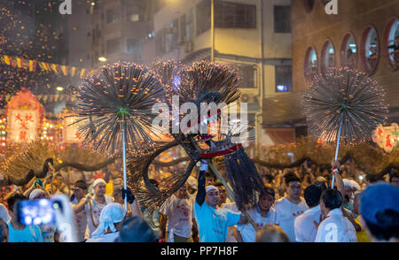 Hong Kong, Hong Kong, China. 24th Sep, 2018. The annual Tai Hang Fire Dragon Dance welcomes in this years mid-autumn festival.The century old festival, now listed as one of Hong Kong's intangible cultural experiences, sees a 67-metre-long dragon, containing over 70,000 incense sticks carried by performers through the narrow streets. Drummers and other performers to entertain the crowds while the fire dragon scares off evil spirits. Credit: Jayne Russell/ZUMA Wire/Alamy Live News Stock Photo