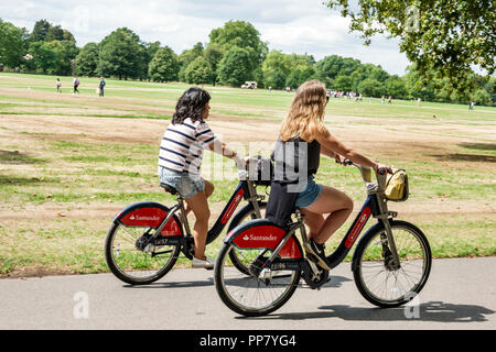 London England,UK,Hyde Park,historic Royal Park,Broad Walk path,lawn,woman female women,riding,bicycle bicycles bicycling riding biking rider riders b Stock Photo