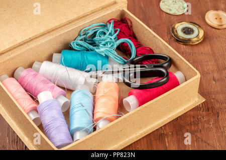 A closeup photo of a sewing box with threads and scissors, with beads and buttons, and copy space Stock Photo