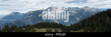 mountain landscape in the Swiss Alps above Maienfeld with many peaks and forests and valleys below in early autumn Stock Photo