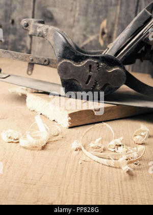 Old used wood plane on a work bench using as traditional wood working background Stock Photo
