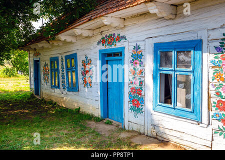 Zalipie, Poland, August 19, 2018:  Colourful house with flowers painted on walls and sundial in the village of Zalipie, Poland. It is known for a loca Stock Photo