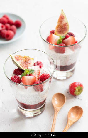 Chia seed pudding in glass with fresh berries on white background. Closeup view, selective focus. Healthy eating, healthy lifestyle concept Stock Photo