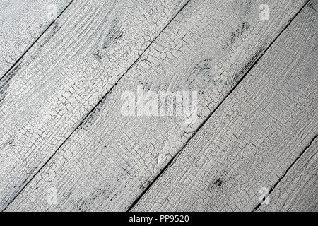 Close-up of natural wooden planks painted in white color with craquelure effect. Textured white and grey aged background with diagonal layout and copy Stock Photo