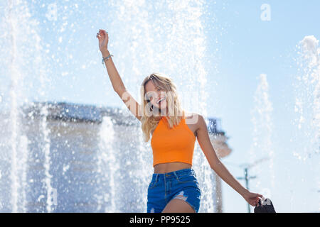 Delighted nice woman standing with her shoes in the hand Stock Photo