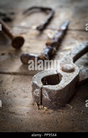 Old rusty tools in the workshop on an old wooden table Stock Photo
