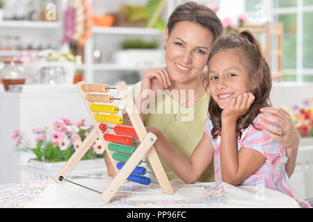 Portrait of mother with little daughter studying Stock Photo