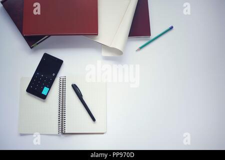 Study stuff. Education background. Stationery.  Aspects of education. Marker, paper, pencil, notebook, books and calculator application opened on mobi Stock Photo