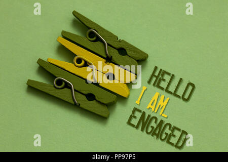 Handwriting text writing Hello I Am... Engaged. Concept meaning He gave the ring We are going to get married Wedding Olive ground laid on paperclip in Stock Photo
