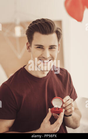 Excited smiling man showing costly engagement ring to his best friend Stock Photo