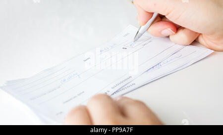 Closeup image of person writing bank cheque for charity purposes Stock Photo