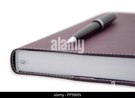close-up view of tip of ballpoint pen laying on the notebook Stock Photo