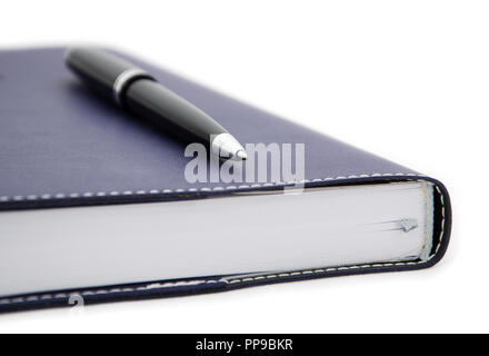 close-up view of tip of ballpoint pen laying on the notebook Stock Photo