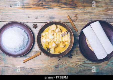 Thai massaman curry (chicken curry) with cinnamon sticks and plane riсe on wooden background. Coconut milk curry. Stock Photo