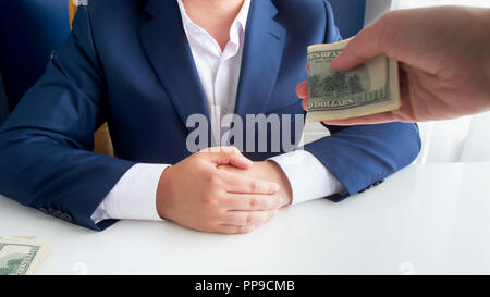 Closeup photo of person offering bribe to corrupted politician in office Stock Photo