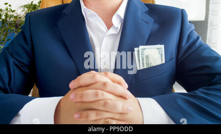 Closeup image of big stack of money showing from businessman's jacket pocket Stock Photo