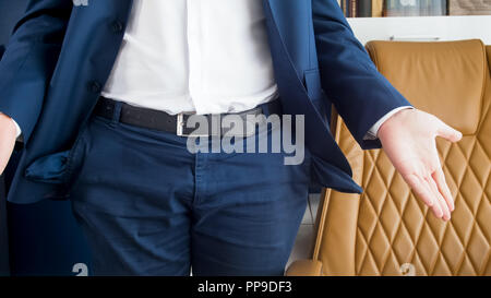 Closeup image of businessman standing at office and showing his empty pockets Stock Photo