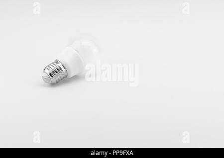 LED low power bulb on a white surface backdrop Stock Photo