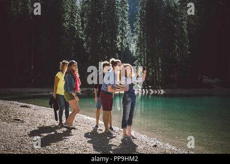 Group of friends having a walk on a mountain lake - Young people exploring the nature Stock Photo
