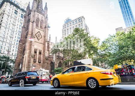 New York, USA - SEPTEMBER 17, 2017: Trinity Church in Lower Manhattan and street with tourists and traffic New York USA. It is a historic parish churc Stock Photo