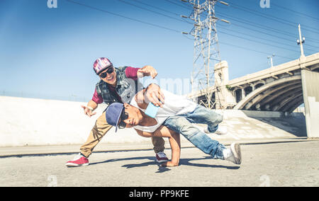 Two bbys doing some stunts - Street artist breakdancer taking an acrobatic selfie outdoors Stock Photo