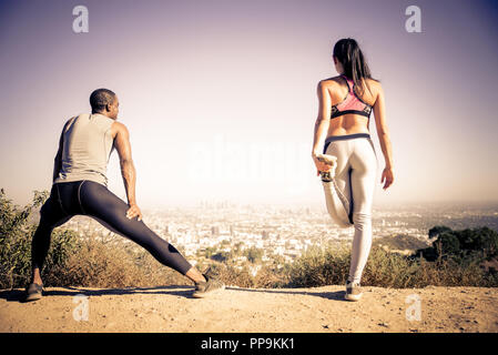 Couple of  joggers doing stretching before starting to run Stock Photo