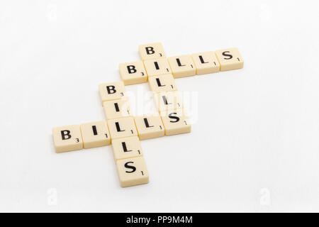 Letter tiles spelling out aspects of personal finances / financial management, financial crisis, running up bills, debts etc. Stock Photo