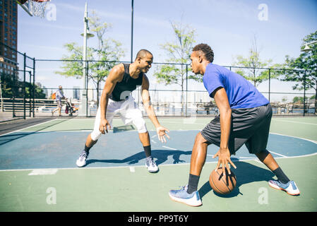 Two afroamerican athlethes playing basketball outdoors - Basketball athlete training on court in New York Stock Photo