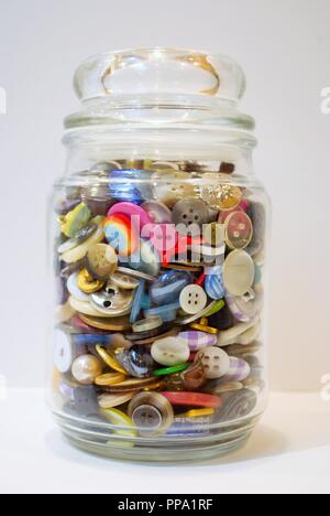 jar full of multi colored buttons overflowing Stock Photo