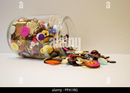 jar full of multi colored buttons overflowing Stock Photo