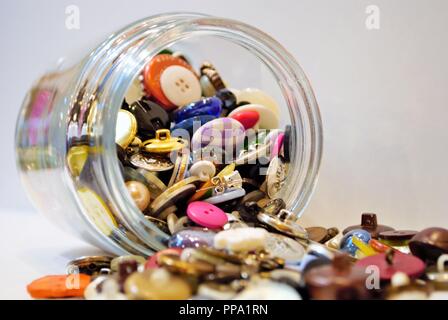jar full of multi colored buttons overflowing Stock Photo