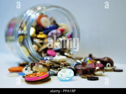 jar full of multi colored buttons overflowing Stock Photo