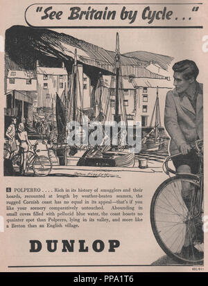 Vintage Dunlop magazine advertisement 'See Britain by cycle' dated to November 1946. It shows an illustration of Polperro in Cornwall with a brief romanticised description of the town. Stock Photo