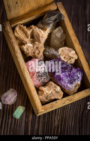 Collection of decorative stones and minerals in a small wooden box Stock Photo