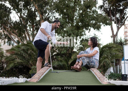 man giving golf lesson to woman Stock Photo