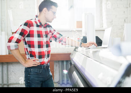 Man using laptop in publishing office Stock Photo