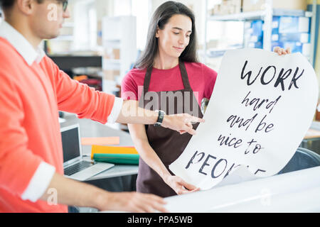 Coworking colleagues with printed poster Stock Photo