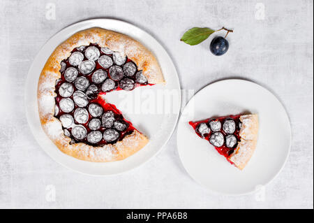 Homemade traditional plum galette on the white plate, top view Stock Photo