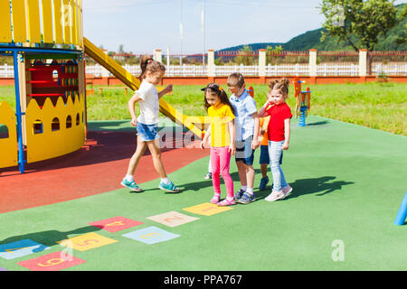 Children learn to play hopscotch in the summer outdoors Stock Photo