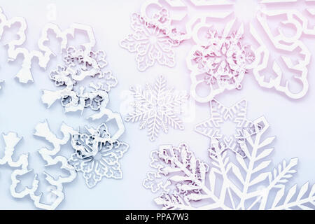 Abstract christmas background, snowflakes of different shapes and colors, blurred selective focus. Light backdrop for design with text Stock Photo