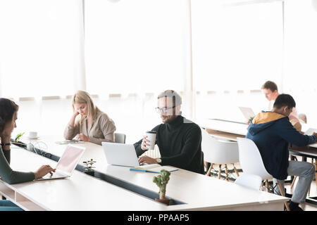 Group of people working at desks in big modern workspace, copy space Stock Photo