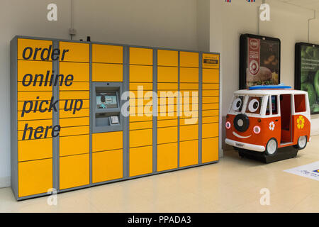 Yellow Amazon lockers and pick up point for packages ordered online in an indoor shopping centre, UK Stock Photo