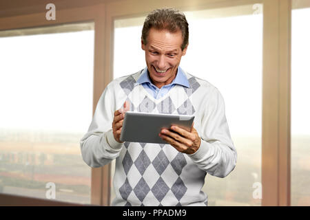 Portrait of joyful man talking using tablet. Stock Photo