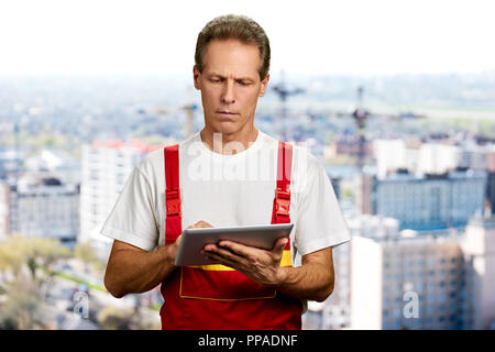 Middle aged engineer using digital tablet. Stock Photo